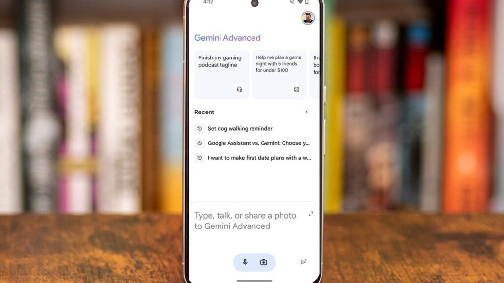 スマートフォンのディスプレイにGemini Advancedのアプリ画面が表示されている。画面上部に「Gemini Advanced」の青いテキスト、複数の提案タスクが並んでいる。