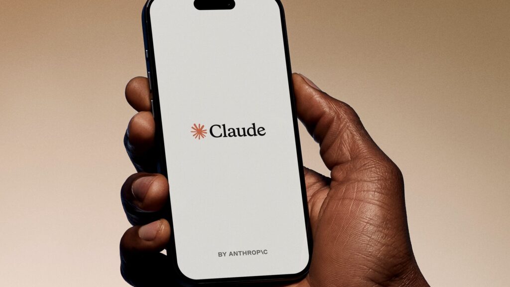 手元でスマートフォンを持ち、ClaudeのロゴとBY ANTHROPICの文字が表示された起動画面の写真。Anthropic、Bunに型チェック搭載 0.66秒が0.20秒になった