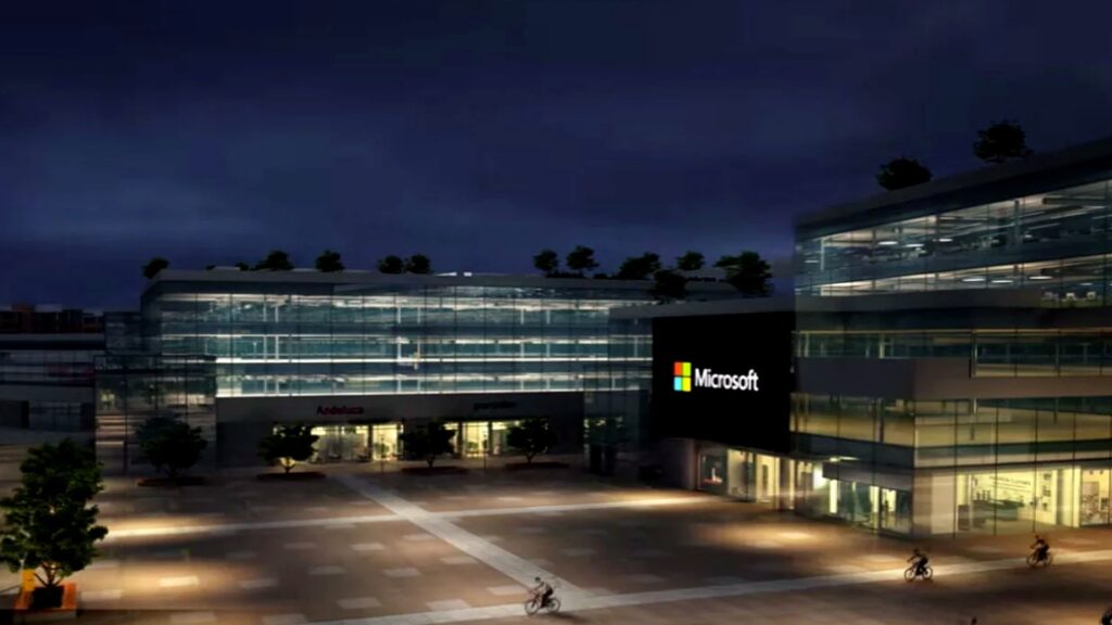 夜のオフィスビル壁面にMicrosoftのロゴが表示され、広場を自転車の人物が走る様子の写真。GitHub、Copilot Fusion公開 Cursorより月2ドル高い