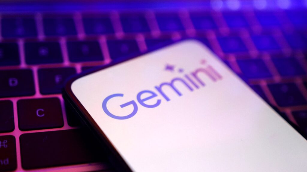 キーボードの上に置かれたスマートフォンにGeminiのロゴが表示された画面。Google、Gemini 4 Carbon発表 1位でもAPIは404だ