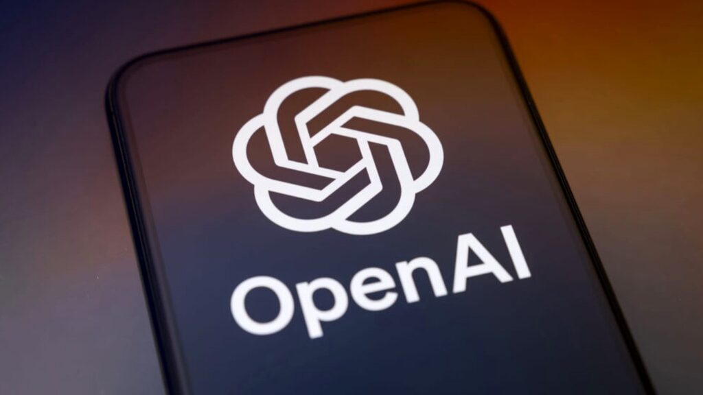 オレンジと紫のグラデーションを背景に、スマートフォンの画面いっぱいにOpenAIのロゴと社名が表示されている写真。OpenAI、選挙の偽画像を漫画風に変える APIでは9回中7回が写真調だ