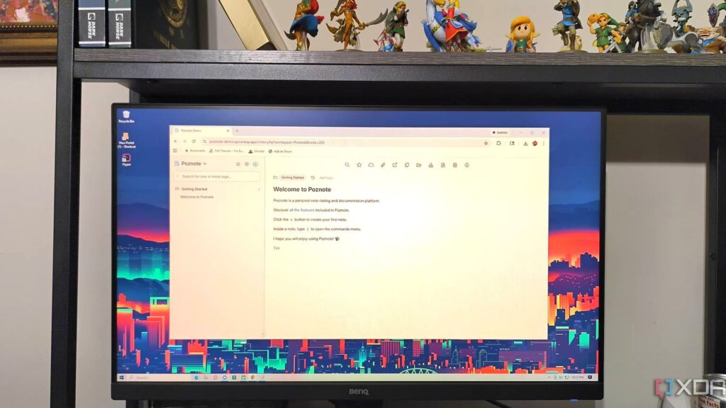 Poznoteのメモアプリ画面を表示したパソコンのモニターと背後の棚に並ぶゼルダのフィギュアの写真。Poznote、AIでメモを要約できる 画面の8言語に日本語は入っていない
