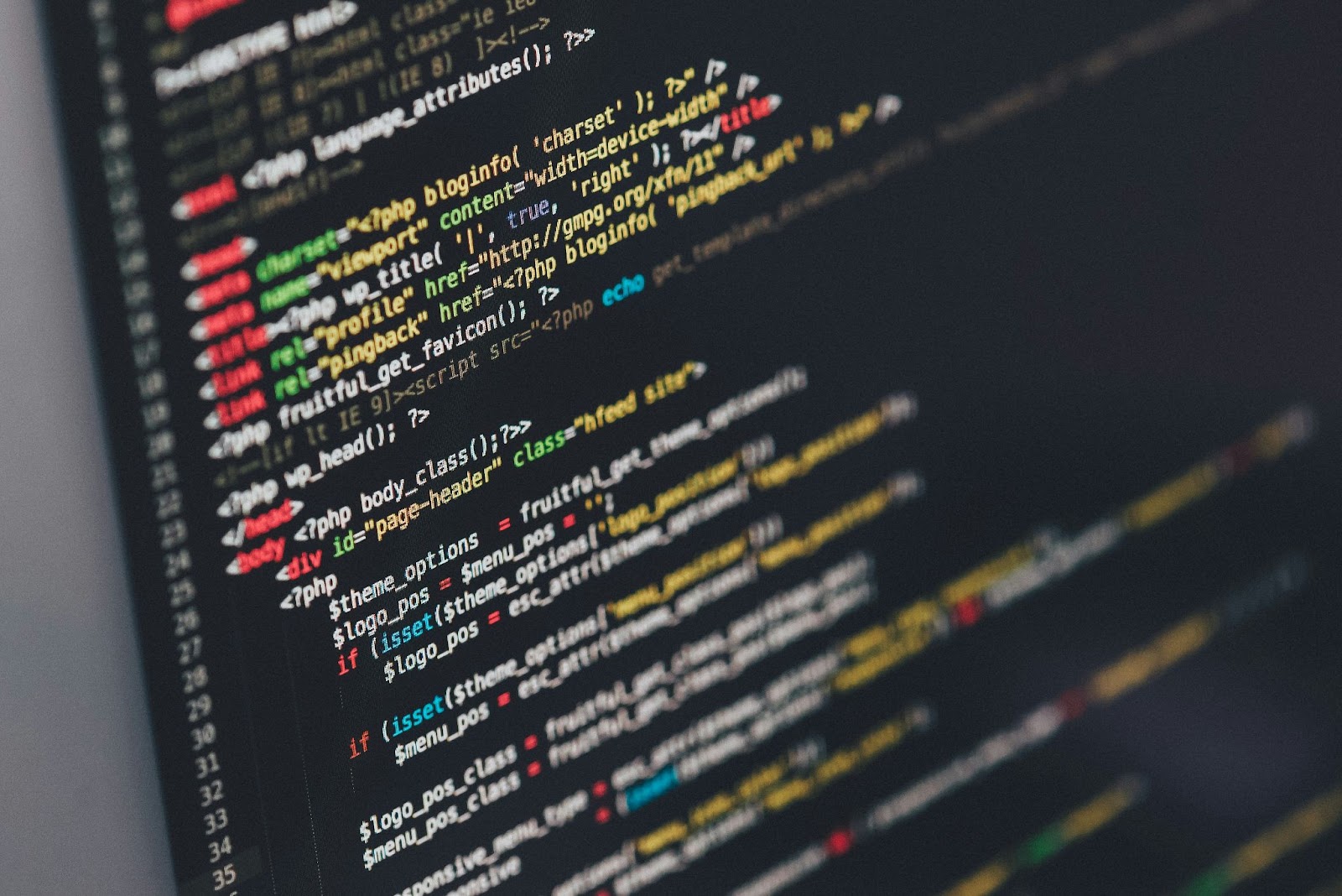 暗い画面に色分けされたPHPのプログラミングコードが斜めに並んだ様子を近くから写した写真