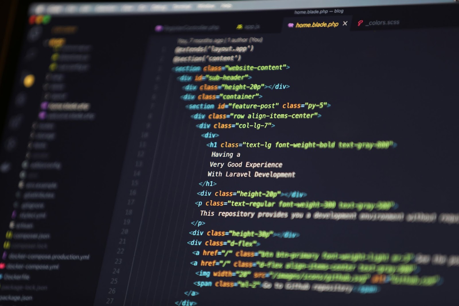 左にファイルの一覧、右に色分けされたWebページのコードが並ぶコードエディタの画面を近くから写した写真