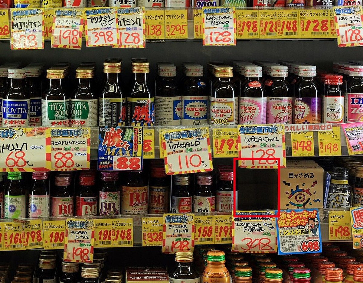 コンビニのドリンク剤の棚の写真。下から2段目の右寄りに1列ぶん商品が無い所を赤枠で囲んだ画面